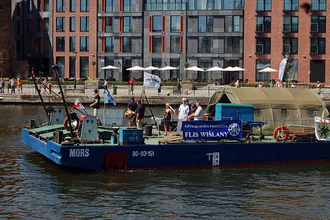 Work pontoon and plant moored against a city quay